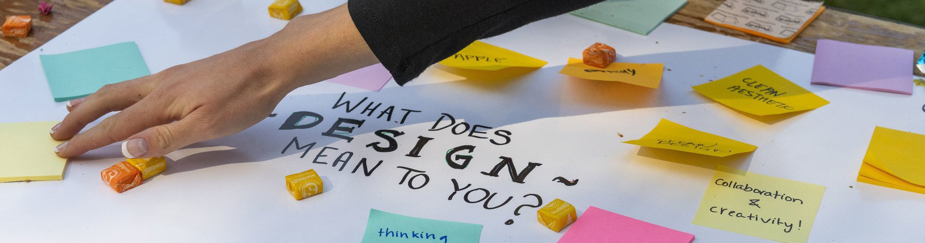 Hand placing sticky notes over a design board