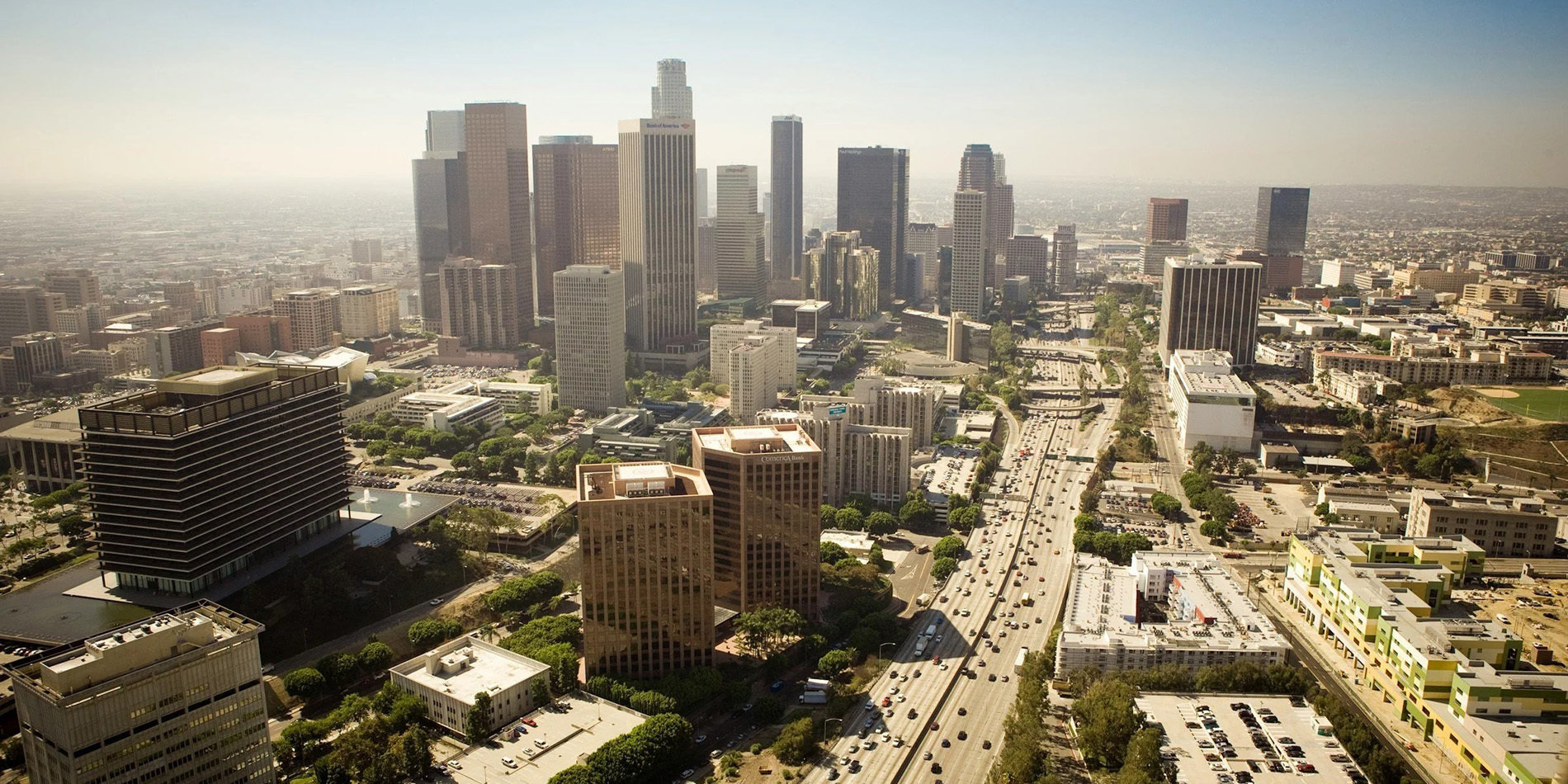 Aerial view of city with tall buildings and highway running through it